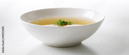 Obraz na płótnie beautiful bowl of clear broth with green onions floating on top, showcasing simplicity and elegance in presentation w salonie