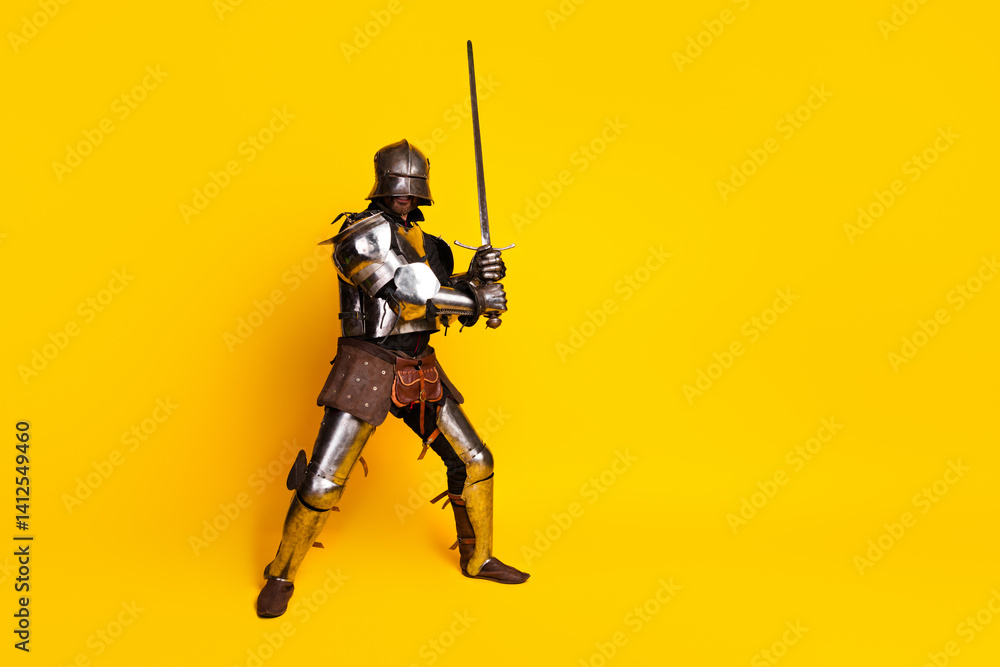 Portrait of a knight in authentic medieval armor with a sword on a bright yellow background Portrait of a knight in authentic medieval armor with a sword on a bright yellow background