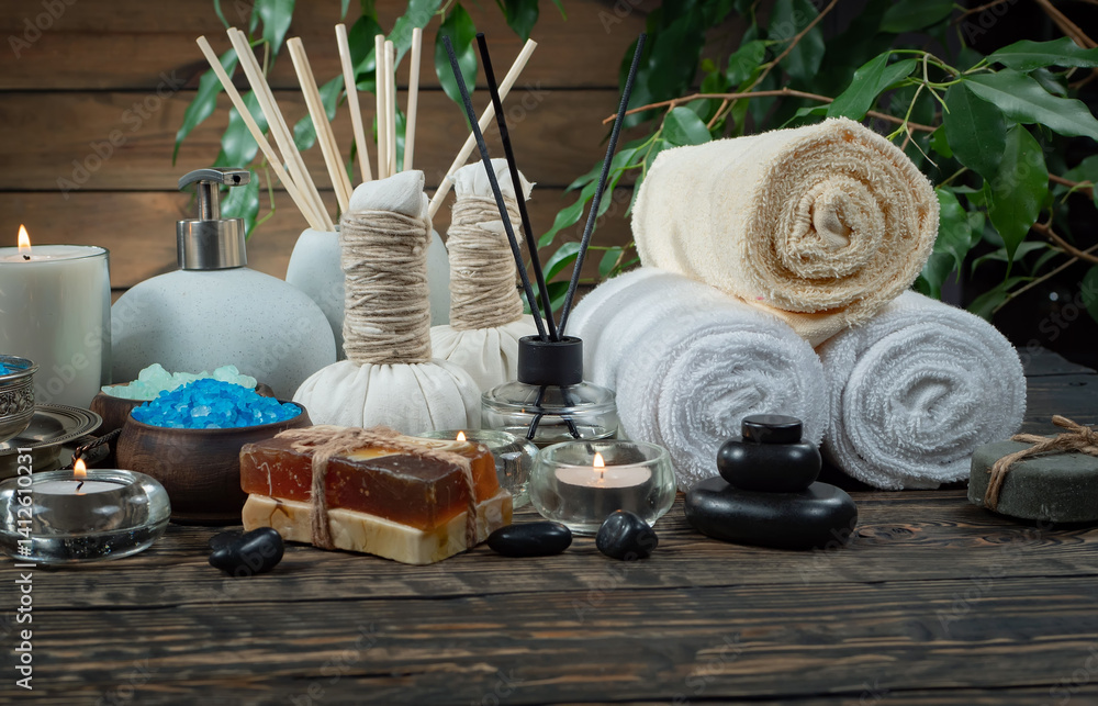 Spa treatment with candles and towel on wooden table, closeup