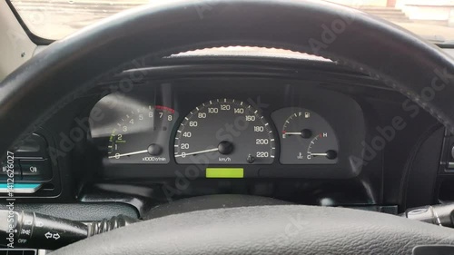 interior of an old car. analog instrument panel. old dial gauges in cars. Old VHS tape effect: a male hand driving a car and increasing the speed, camera pointed at the dashboard.