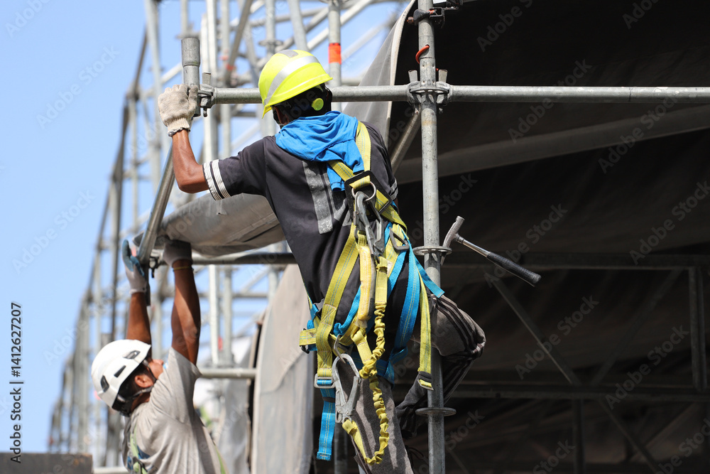 Workers with harnesses and safety helmets working at height during stage assembly
Workers with harnesses and safety helmets working at height during stage assembly