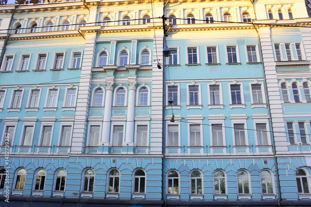 Obraz premium Romantic view of a historical city building in the old town of Vintage architecture classical facade of a four-story remodeled house. Front view. Europe Bright summer day, ancient stone balcony 