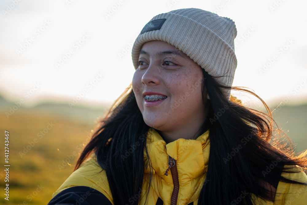 Outdoor adventure happy woman in yellow jacket at viewpoint