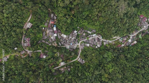 Aerial top view of a village nestled in a valley, green trees in Mae Kampong village of Chiang Mai province, mountain valleys in Asia, Thailand. Horizontal background of nature.