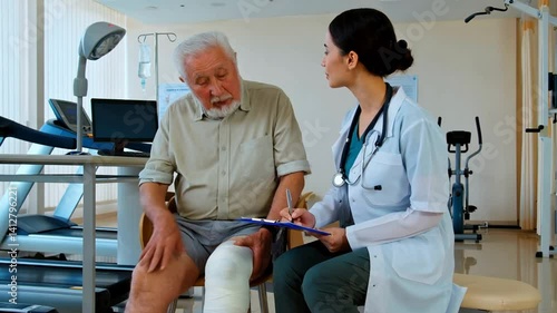 Wallpaper Mural Senior Man with Knee Sports Tape Consulting Young Female Doctor About Leg Injury in Modern Rehabilitation Center Torontodigital.ca