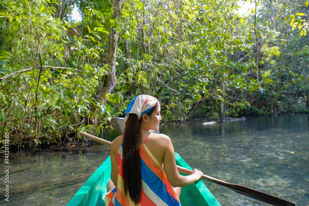 woman in colorful dress enjoys serene boat ride through lush greenery and clear waters