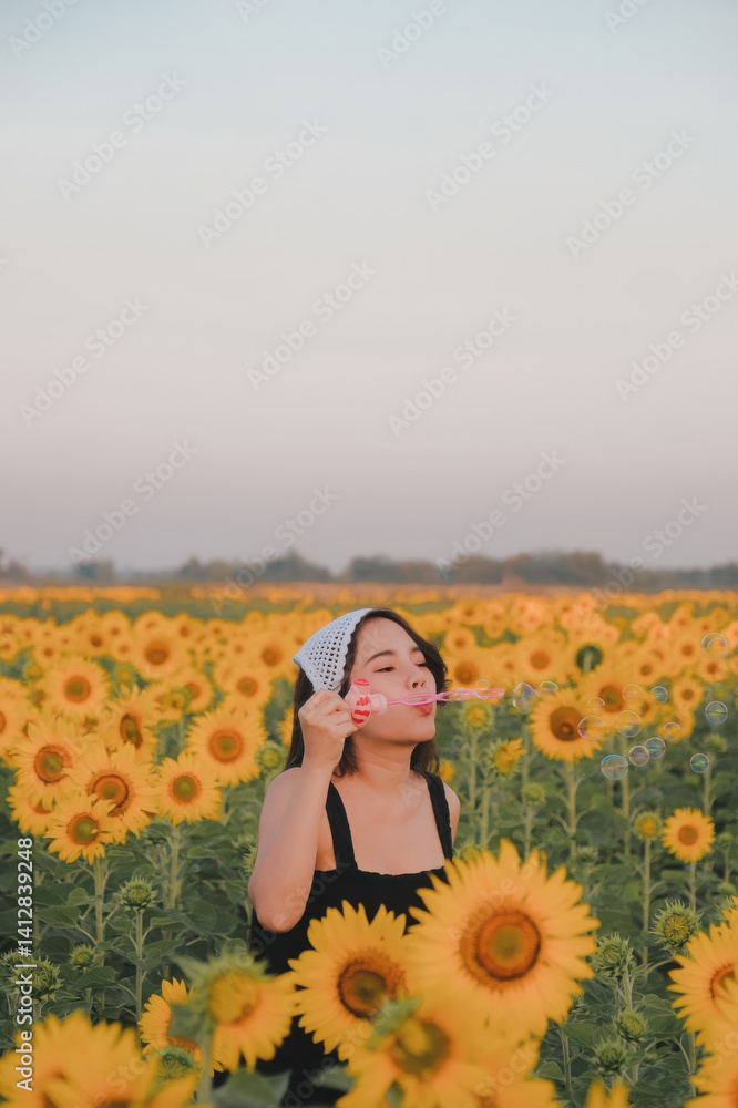 woman joyfully blows bubbles in vast sunflower field under clear sky