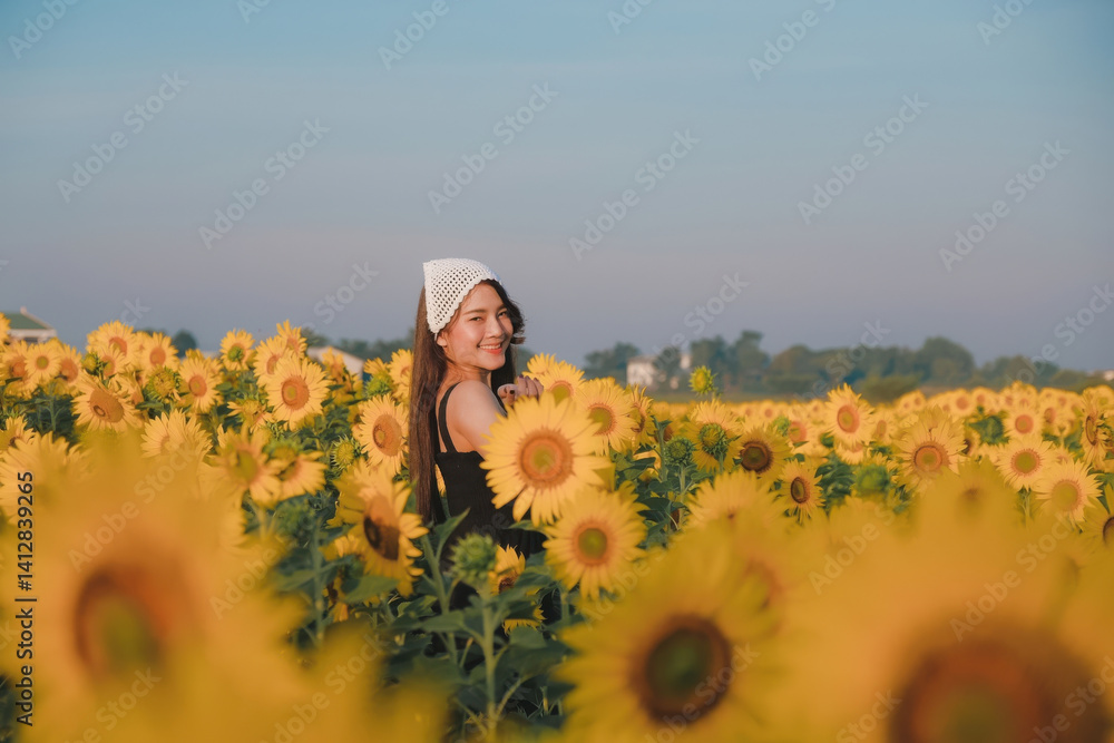 woman joyfully stands in vibrant sunflower field under clear blue sky