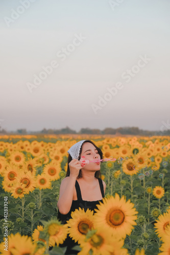 Obraz na płótnie woman joyfully blows bubbles in vast sunflower field under clear sky w salonie