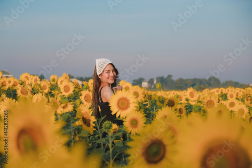 woman joyfully stands in vibrant sunflower field under clear blue sky
