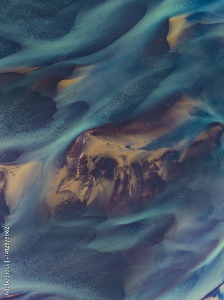 erial abstract view of Icelandic river delta patterns at low tide, with vivid blue and golden tones blending in smooth organic shapes. Nature’s art captured from above.