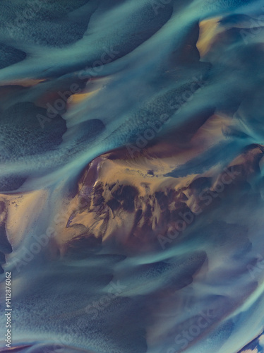 Obraz na płótnie erial abstract view of Icelandic river delta patterns at low tide, with vivid blue and golden tones blending in smooth organic shapes. Nature’s art captured from above. w salonie