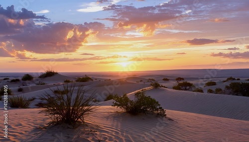a vibrant sunset casts warm hues across a sweeping desert landscape dotted with sparse vegetation and undulating sand dunes.