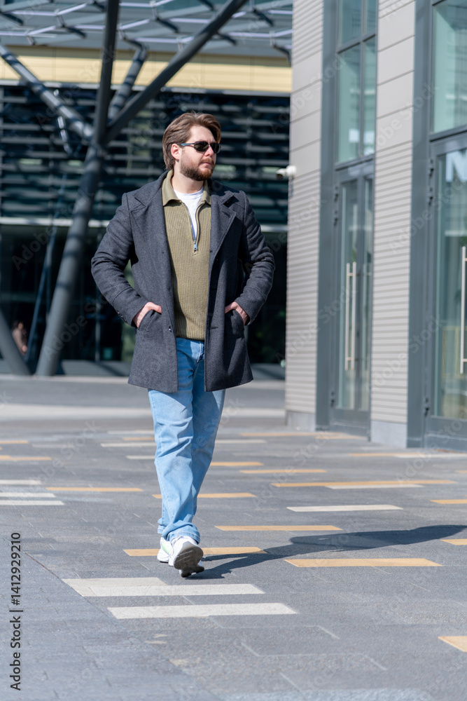 Fashionable man walking in urban setting during bright daytime Fashionable man walking in urban setting during bright daytime