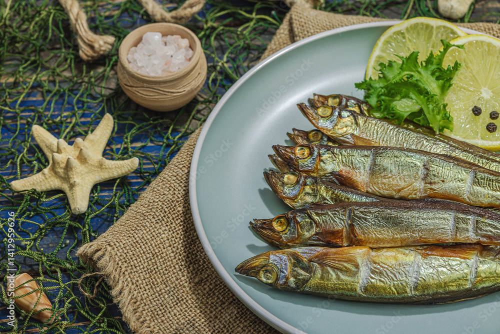 Smoked smelt with fresh lemon and herbs. Salted fish with marine decor. Trendy dish, sea rope Smoked smelt with fresh lemon and herbs. Salted fish with marine decor. Trendy dish, sea rope