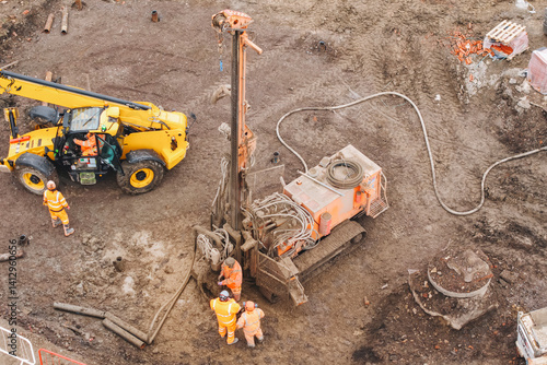Aerial view of construction crew operates heavy drilling piling rig equipment on building site