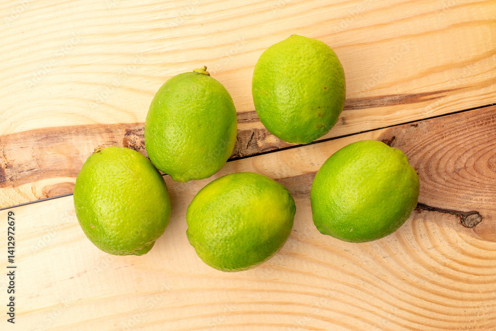 Sour juicy limes on a wooden table, close-up, top view. Sour juicy limes on a wooden table, close-up, top view.