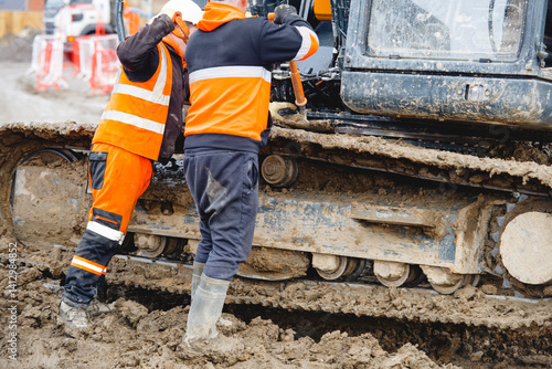 Wallpaper Mural Excavator driver cleans dirt from the tracks of his machine Torontodigital.ca