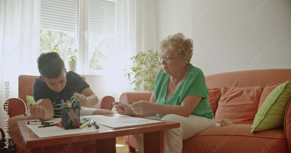 Grandmother and grandson bond over drawing, enjoying quality time together filled with love and learning. Grandmother and grandson bond over drawing, enjoying quality time together filled with love and learning.