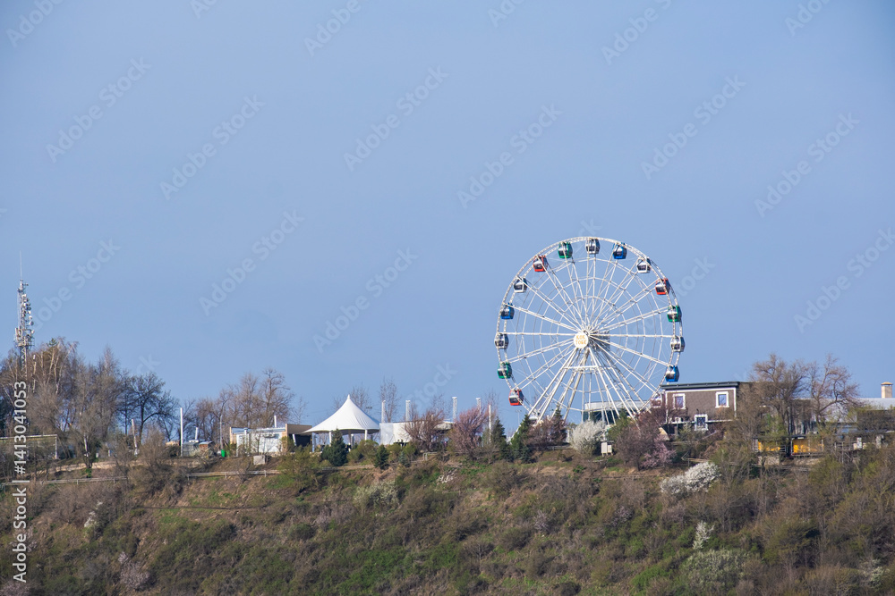 Fototapeta premium April 11, 2025 Almaty Kazakhstan. View of the Ferris wheel on Mount Koktobe.