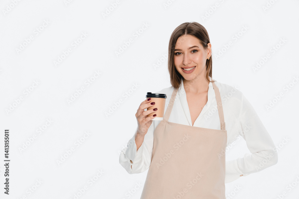 Smiling young female barista woman barman employee in apron looking at camera holding a to-go takeaway craft paper coffee cup in hand isolated over white background. Serving concept copy space
