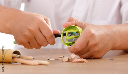 Fotografie Close-up of a child's hands sharpening pencils and crayons