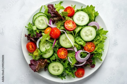 Fresh garden salad with cucumbers tomatoes and onions on white plate