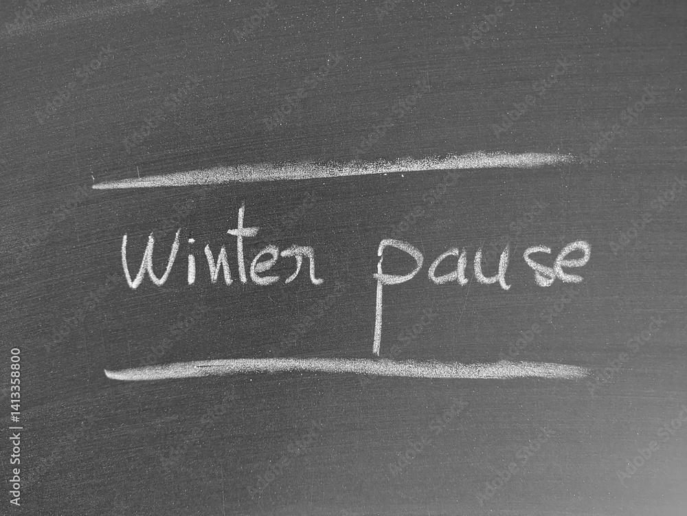 Fototapeta premium Chalkboard message displaying the words 'Winter Pause' between two horizontal lines, symbolizing a break during the cold season.