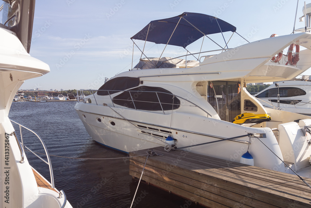 Fototapeta premium Luxury yachts moored at the pier illuminated by the sun