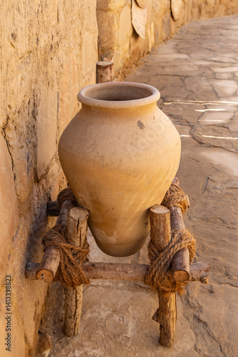 Saudi Arabia, Tabuk Province, Tayma. An amphora on a stand at a desert oasis.