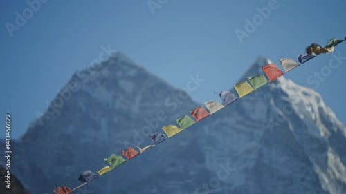 Prayer flags fluttering against snow capped Mount Everest in Dingboche, revealing spiritual Himalayan landscape in vibrant colors