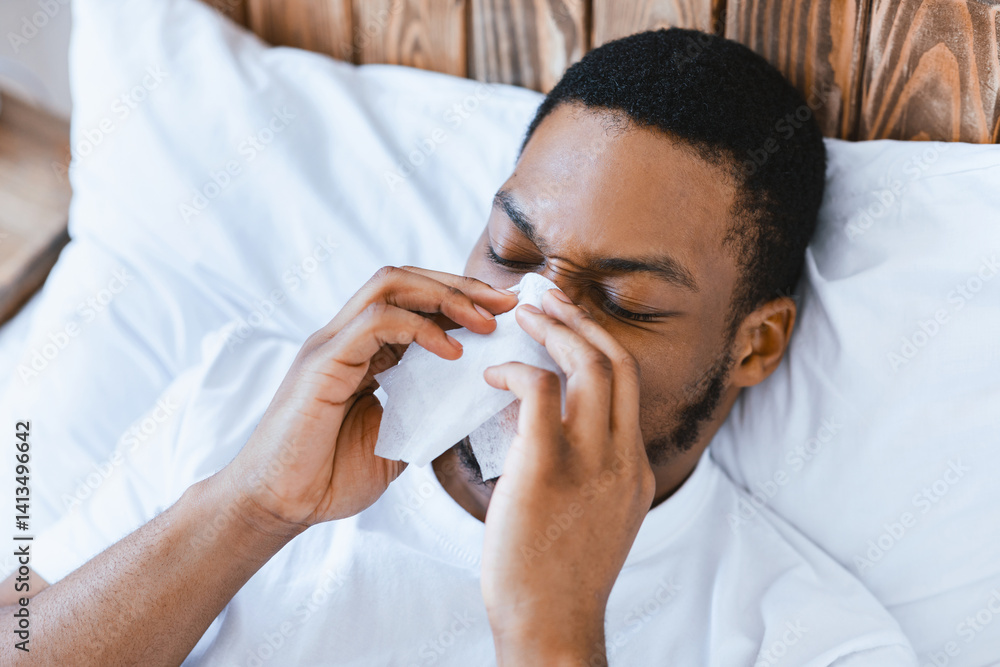 Sick African American Guy Blowing Runny Nose In Paper Tissue Lying In Bed At Home. Ill Black Man Having Rhinitis, Flu And Influenza Disease Symptoms. Cold In The Head Concept. Sick African American Guy Blowing Runny Nose In Paper Tissue Lying In Bed At Home. Ill Black Man Having Rhinitis, Flu And Influenza Disease Symptoms. Cold In The Head Concept.
