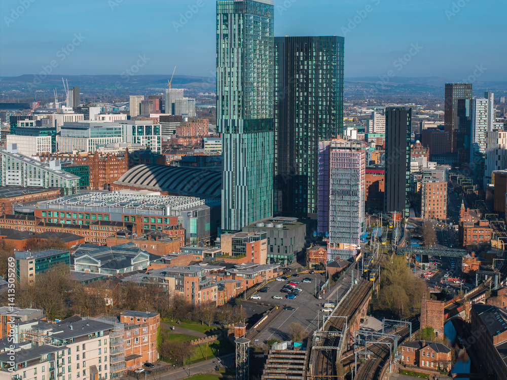 Aerial view of Manchester, UK, featuring Deansgate Square towers, the Manchester Central Convention Complex, railway tracks, and urban architecture.