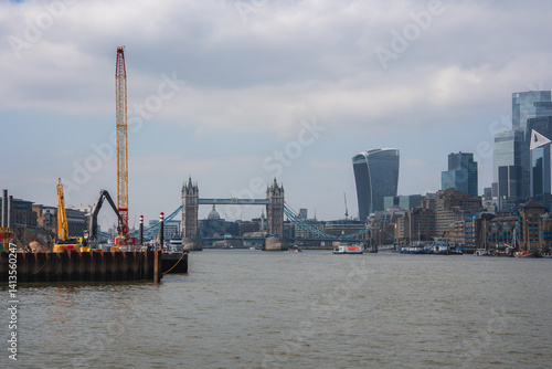 Obraz na płótnie View of Tower Bridge over the River Thames in London, with modern skyscrapers like the Walkie Talkie building and construction cranes on the riverbank. w salonie