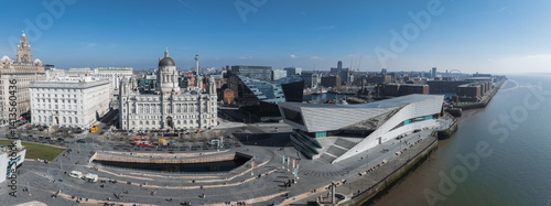 Obraz na płótnie Aerial image of Liverpool's waterfront showing the Royal Liver Building, Port of Liverpool Building, Museum of Liverpool, and bustling promenade by the River Mersey. w salonie