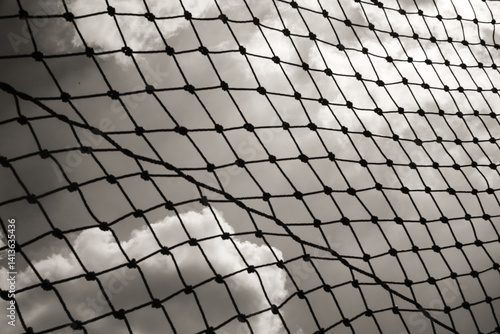 Abstract monochrome goal net with cloud background. Panorama landscape of knot rope in balck and white. Shadow and silhouette. Sports and entertainment. Textured Wallpaper. Copy space