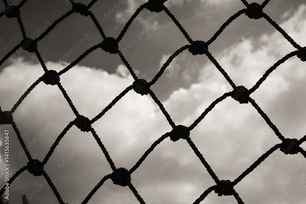 Fototapeta premium Abstract monochrome goal net with cloud background. Panorama landscape of knot rope in balck and white. Shadow and silhouette. Sports and entertainment. Textured Wallpaper. Copy space