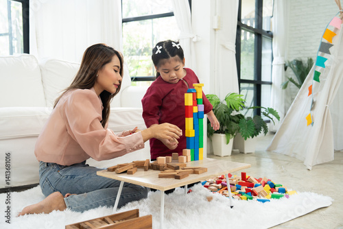 Cherry young mother plays colorful toy block with her Down syndrome daughter,  colorful wooden toys can increase skills and learning to increase the development, special education, Knowing slowly