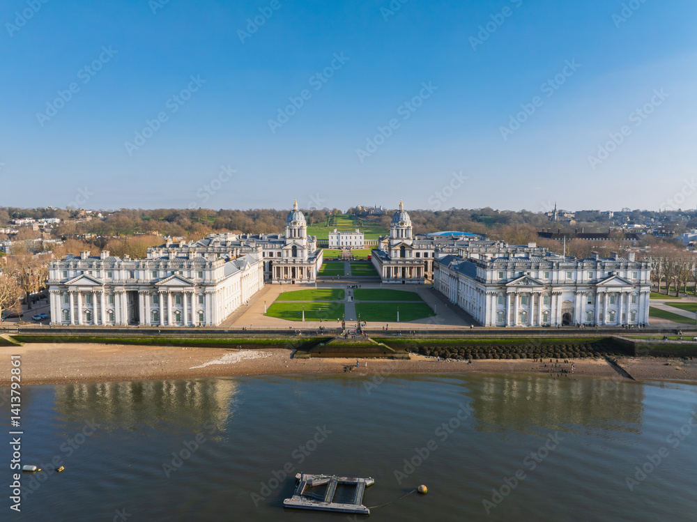 Aerial view of the Old Royal Naval College in Greenwich, London, featuring twin domed buildings, the Queen's House, and the River Thames in the foreground.