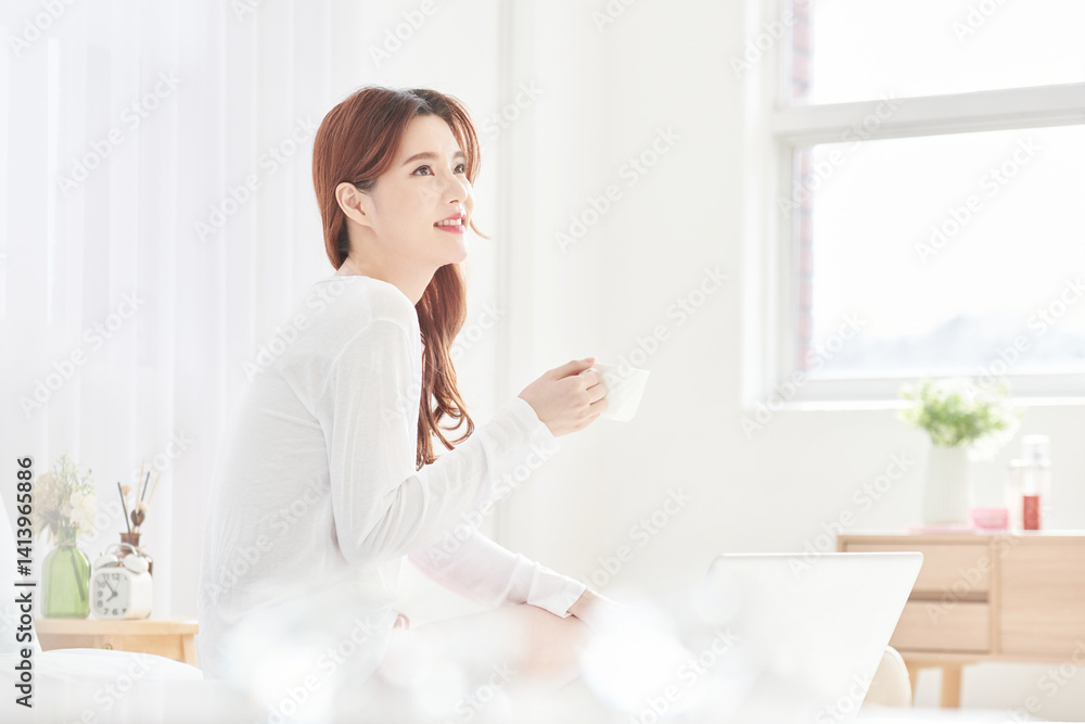 Woman Enjoying Morning Coffee in Bright Bedroom Woman Enjoying Morning Coffee in Bright Bedroom