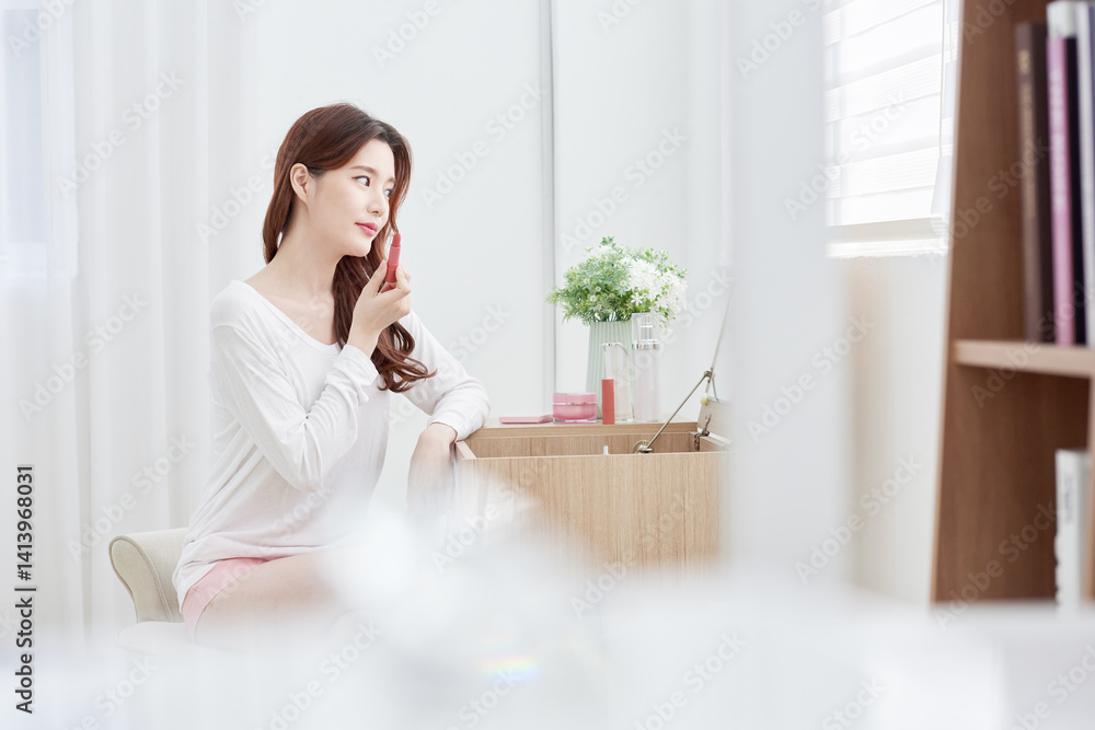 Asian Woman Applying Lipstick at Vanity Table Asian Woman Applying Lipstick at Vanity Table