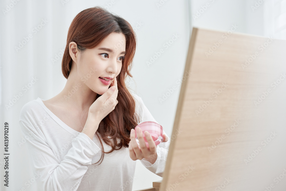 Asian Woman Applying Skincare Product with Pink Container Asian Woman Applying Skincare Product with Pink Container