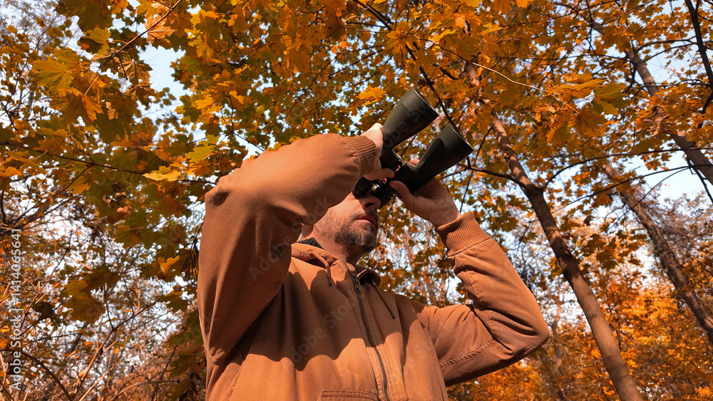 Amateur birdwatcher observing birds and other animals in nature with binoculars.