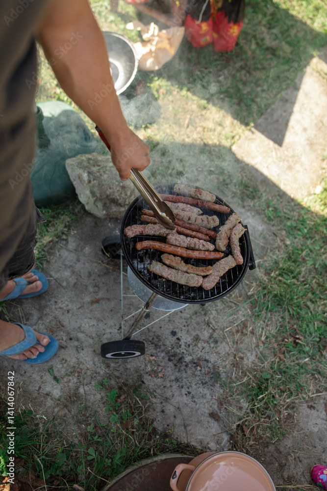 Man preparing barbeque in the garden on a hot summer day.
