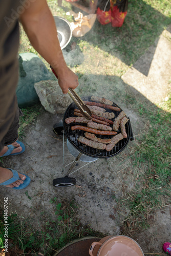 Man preparing barbeque in the garden on a hot summer day.
