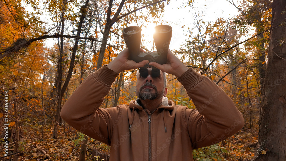 Amateur birdwatcher observing birds and other animals in nature with binoculars.