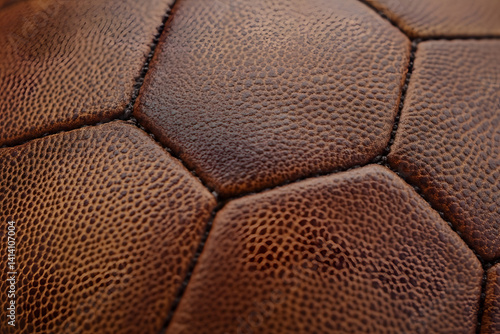 Obraz na płótnie Close-up shot of football showcasing its hexagonal texture and crisp details, captured in studio lighting to highlight leather grain pattern for sport visuals, branding, or educational content w salonie
