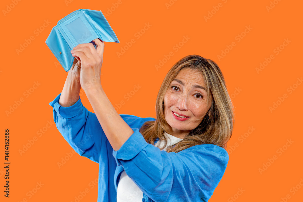 Woman holds a blue wallet excitedly against a vibrant orange background showcasing happiness and surprise during a moment of joy Woman holds a blue wallet excitedly against a vibrant orange background showcasing happiness and surprise during a moment of joy