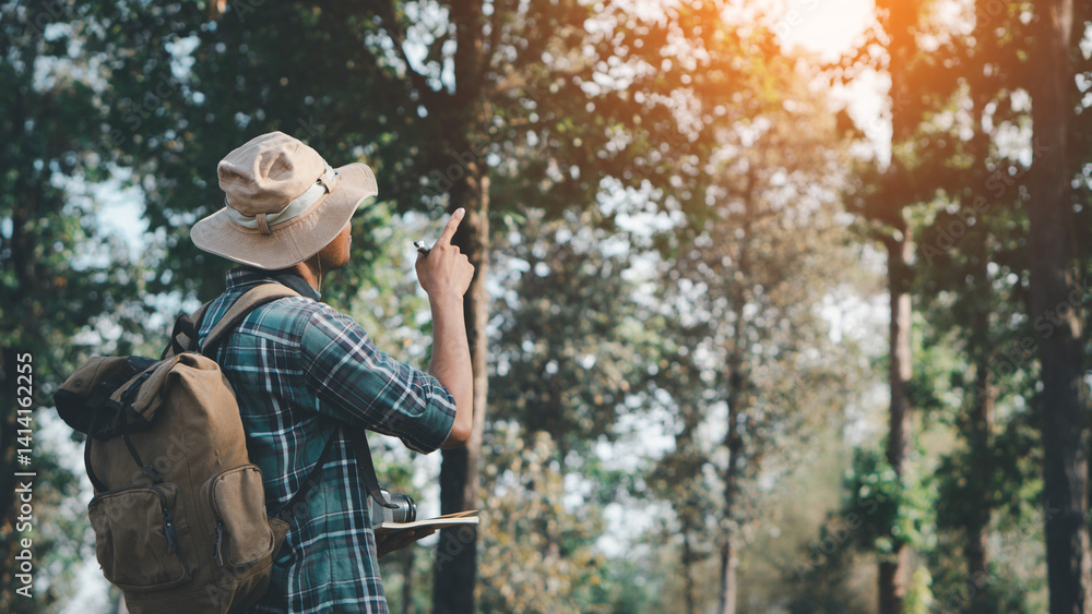 Fototapeta premium Travel and backpack concept. A young man is hiking with a backpack in the forest. Close up legs of young asian hiking man standing, Adventure hikes, Enjoy holidays