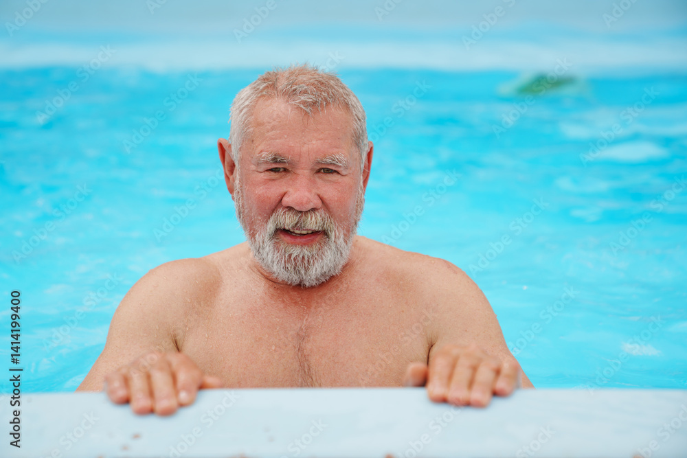 An elderly man with a gray beard in the pool.